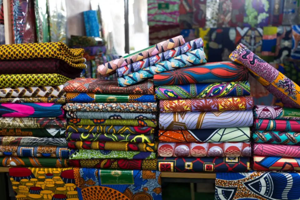 Stacks of colourful printed fabrics in a fabric shop.
