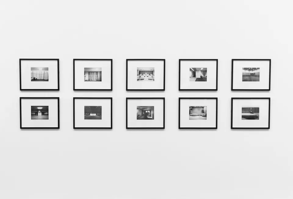 Ten black-and-white architecture prints framed on a white wall.