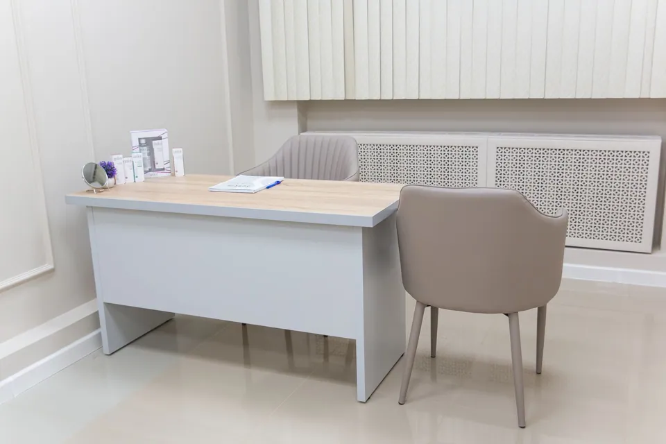 Bureau médical minimaliste avec deux chaises et une table claire.