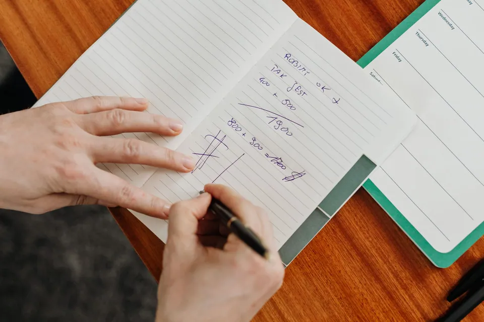 Main prenant des notes et structurant une réflexion.