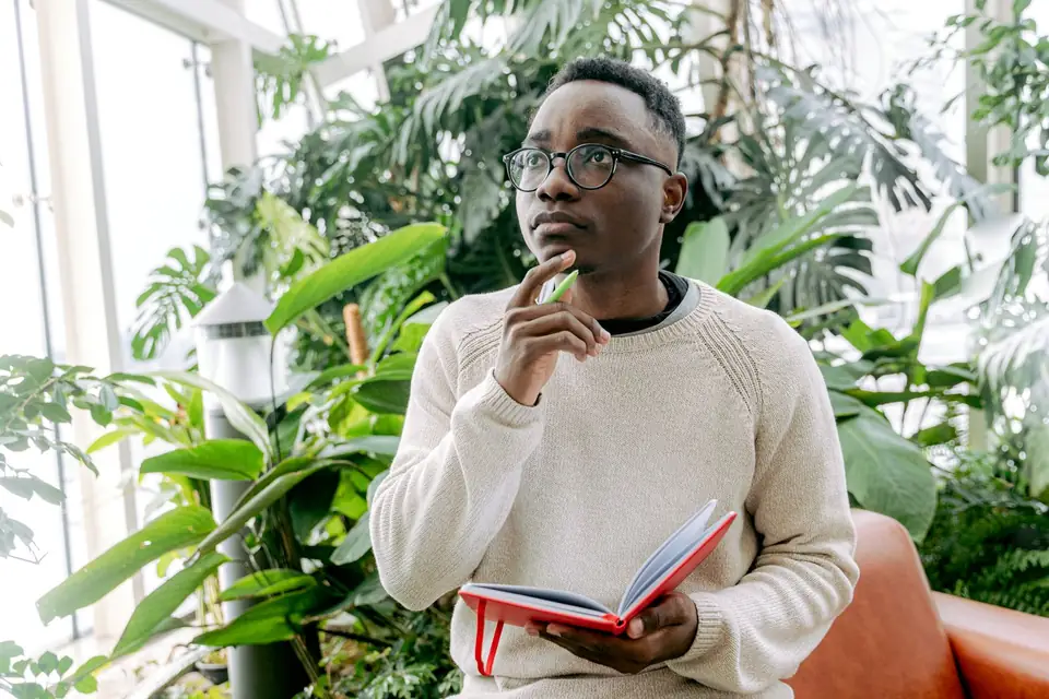 Man thinking with an open notebook in hand.