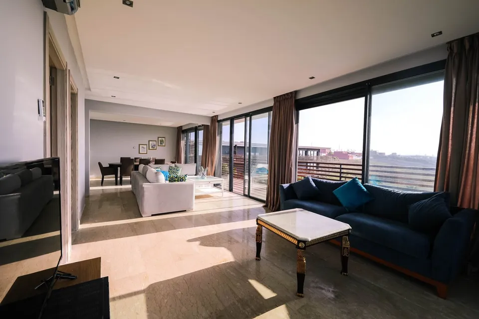 Bright living room with a blue sofa and large picture windows.