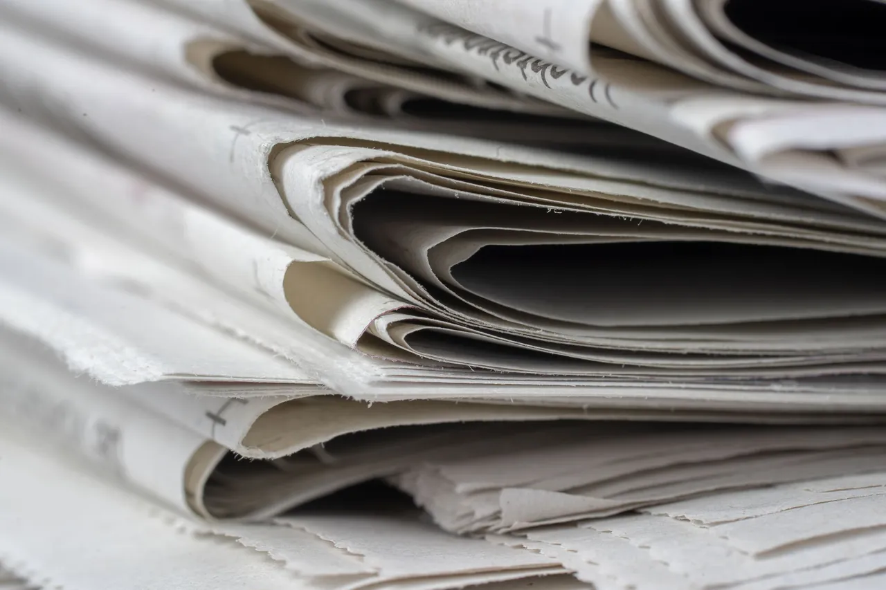 Stack of folded newspapers, close-up on the paper edges.