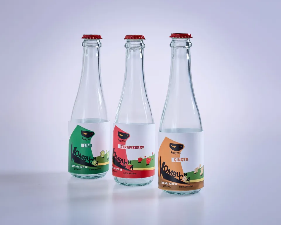 Three drink bottles with illustrated green, red and orange labels.