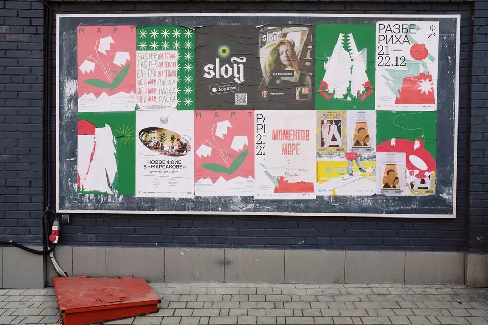 Campaign posters pasted on an urban billboard.