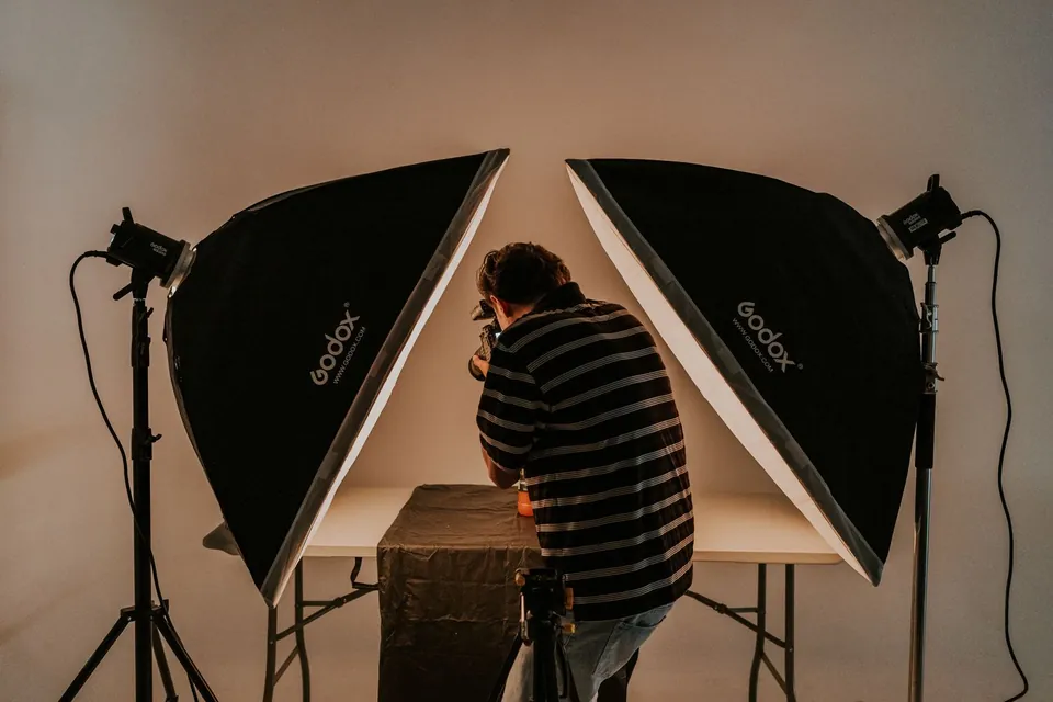 Photographer framing a product between two softboxes in a studio.