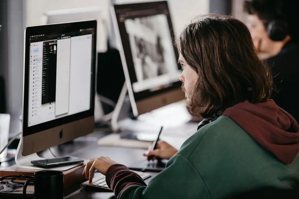 Designer working at a computer screen in a studio.