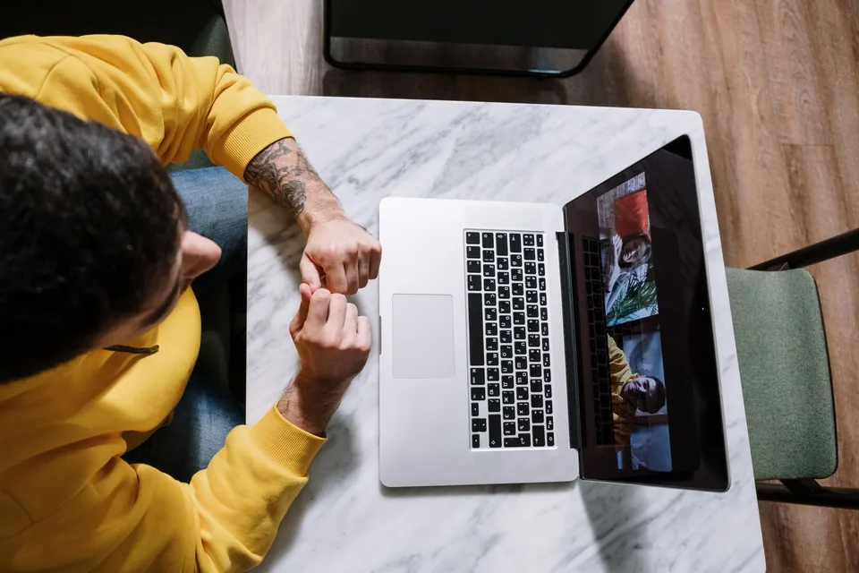 Person on a video call on a laptop, seen from above.