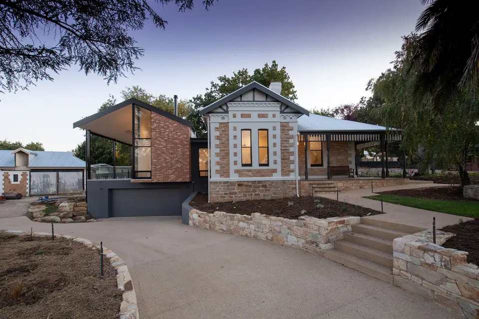Old stone house extended with a brick and glass addition.
