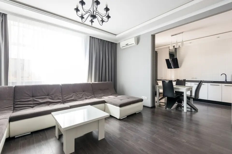 Renovated living room with a corner sofa, dining area and wooden floor.