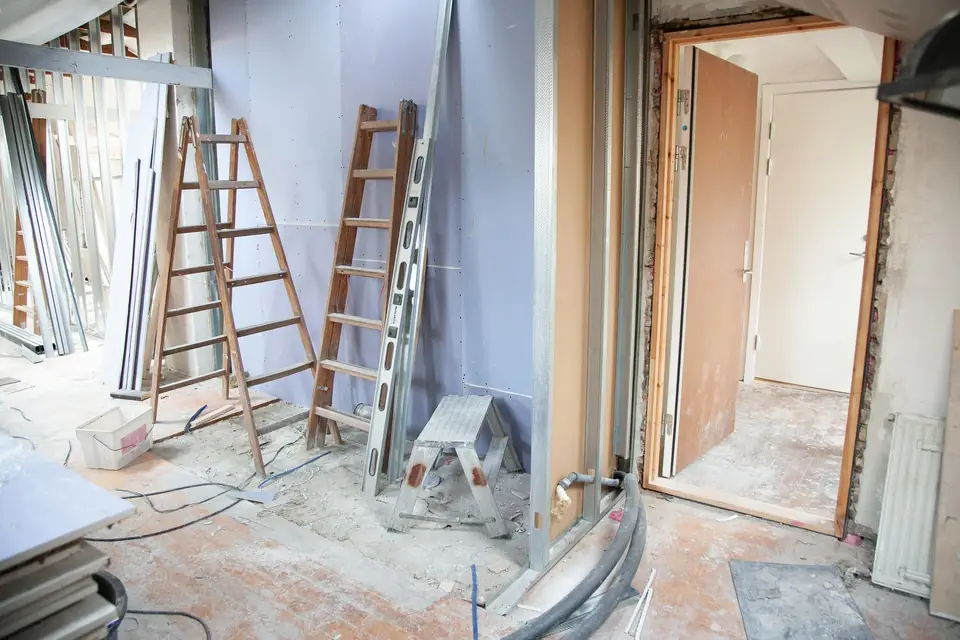 Renovation site with stepladders, tools and open partitions.