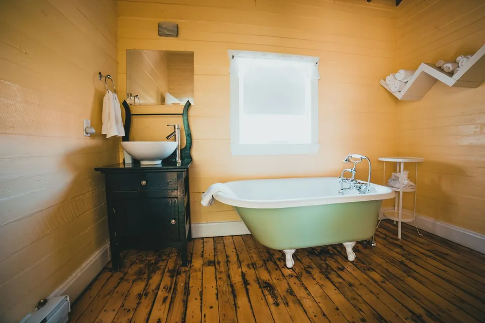 Wood-panelled bathroom with a clawfoot bathtub.