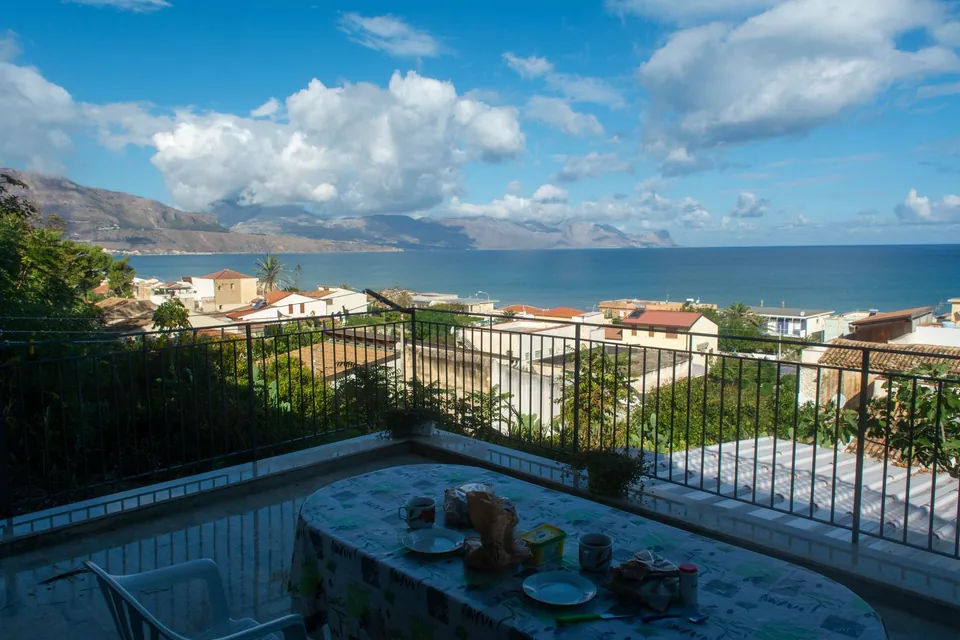 Breakfast table on a terrace overlooking the town and the sea.