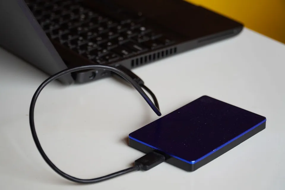 External hard drive connected to a laptop by a cable.