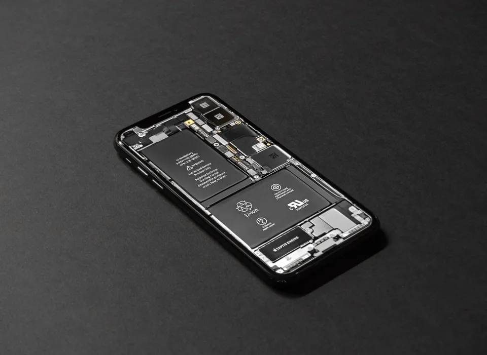 Opened smartphone on a dark background, battery and components visible.