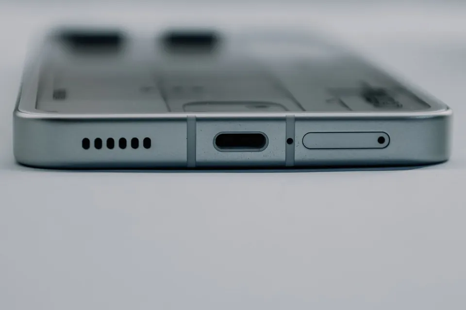 Bottom edge of a smartphone: speaker, USB-C charging port and SIM tray.