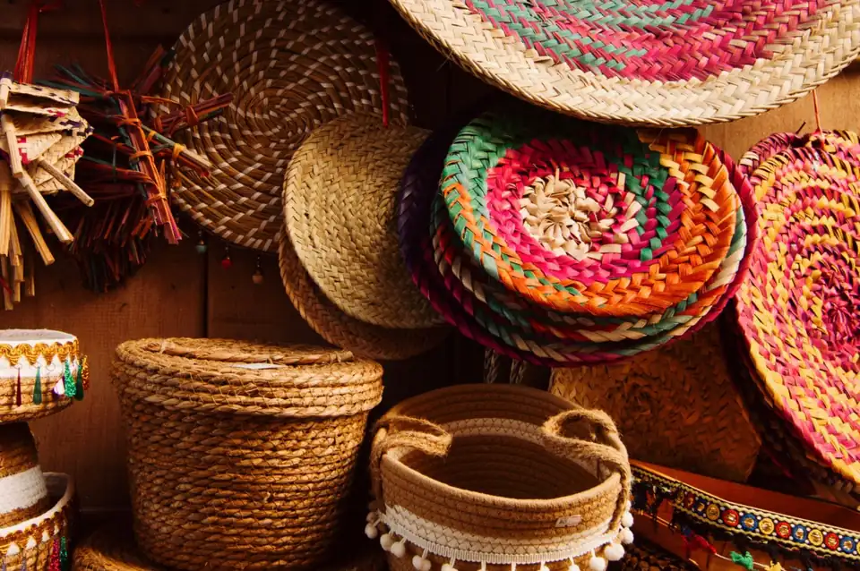 Handwoven baskets and hats in coloured natural fibres.