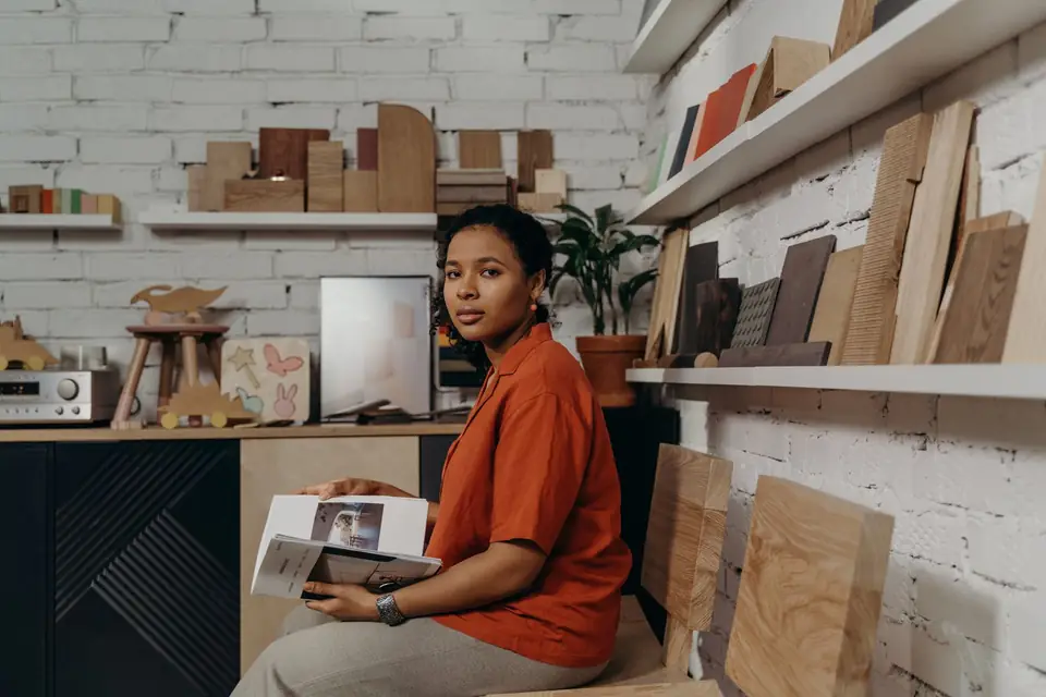 Interior designer looking through a catalogue among wood samples in her showroom.