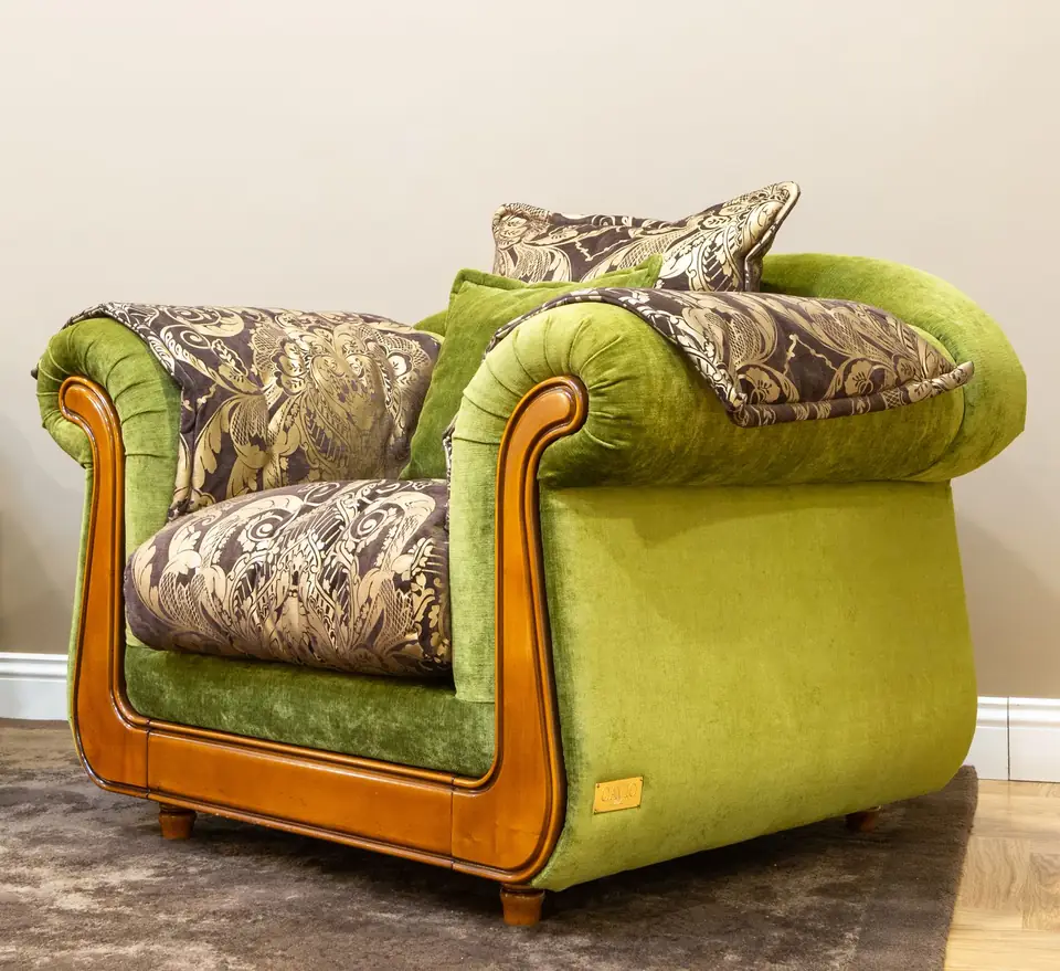 Green armchair with patterned upholstery and a wooden frame.