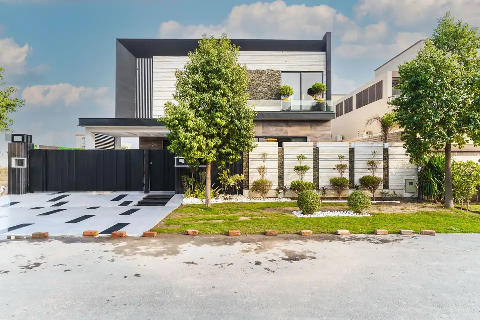 Contemporary two-storey house with a white and grey facade and a planted garden by the entrance.