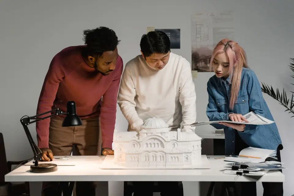 Team reviewing an architectural model together on a table.