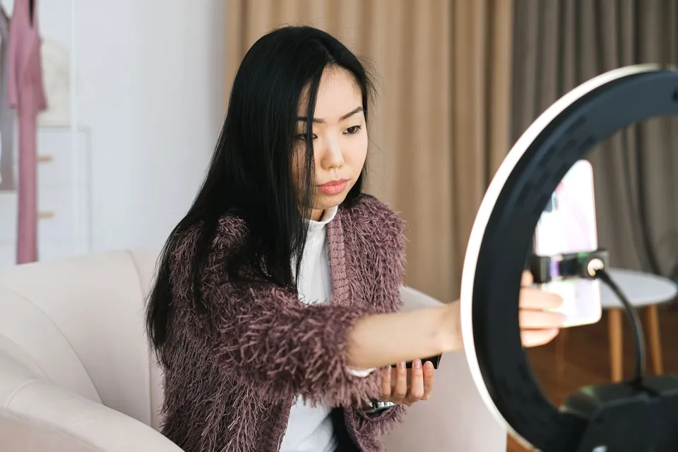 Creator adjusting a phone on a ring light before filming.