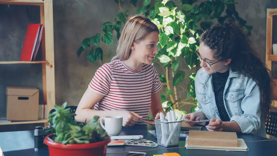Two creatives discussing work documents.
