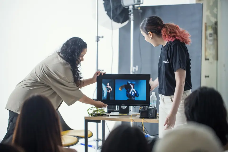 Photographers reviewing images on a monitor during a studio session.