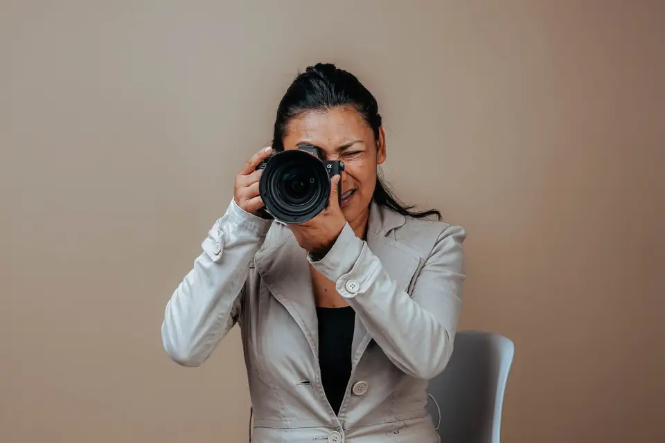 Photographer aiming her camera in a studio.