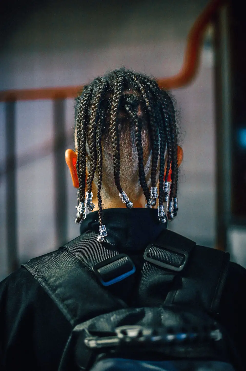 Thin braids finished with beads, seen from behind.