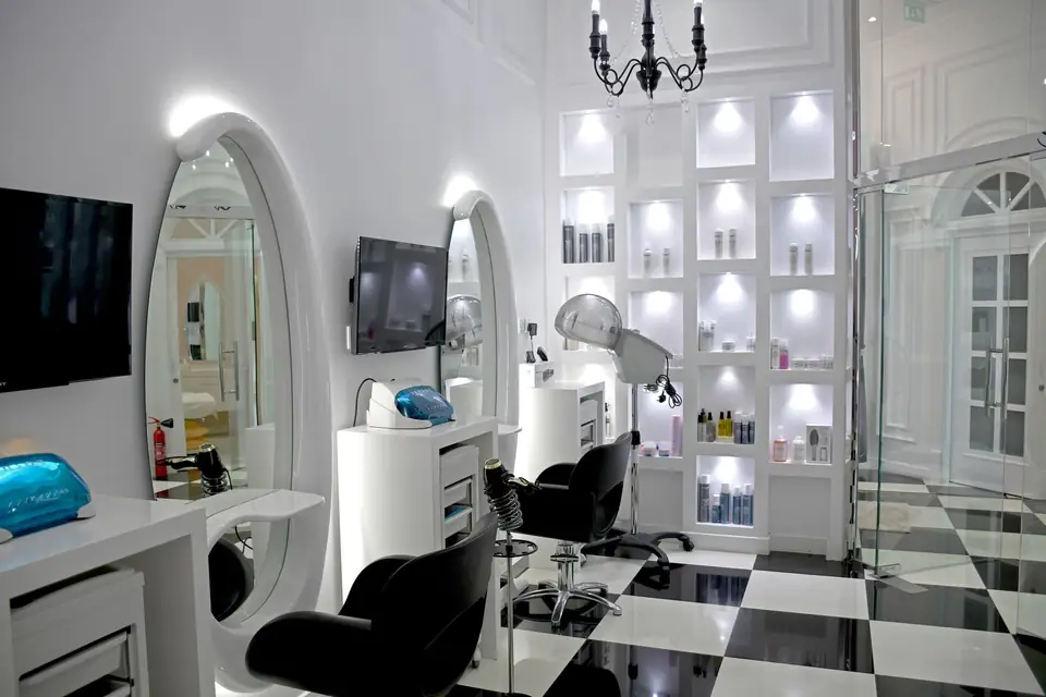 Bright hair salon with oval mirrors and styling stations.