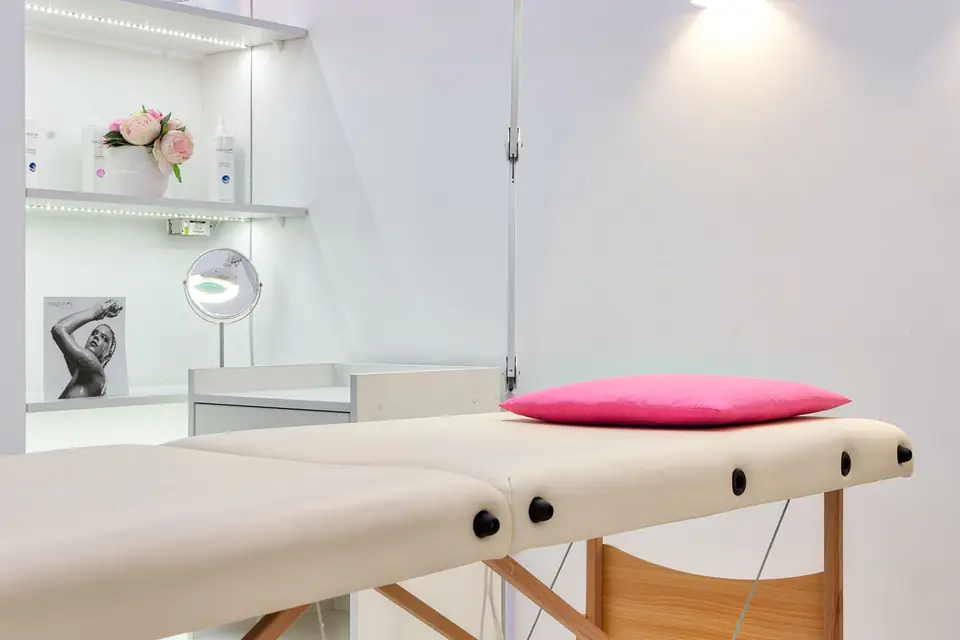 Treatment room with a massage table in soft light.