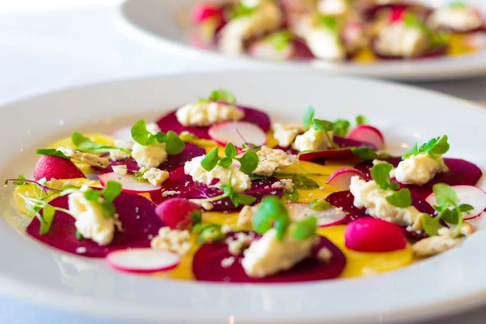 Beetroot carpaccio with radish, fresh cheese and young shoots.