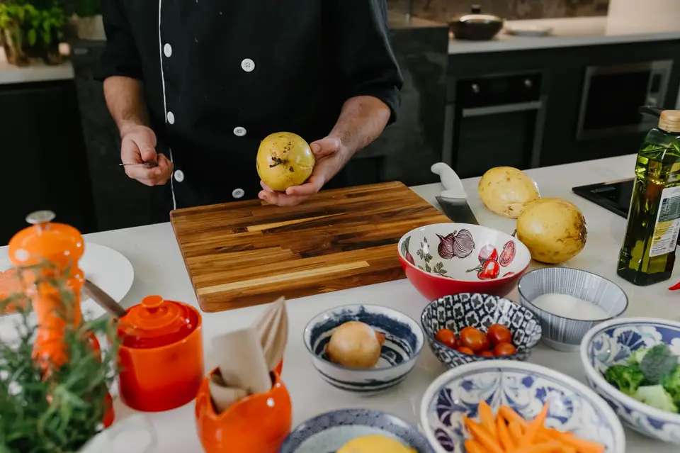 Chef preparing fresh ingredients on a wooden board.