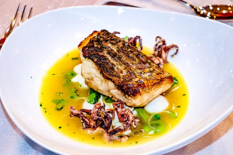 Grilled fish fillet and squid in a saffron broth.