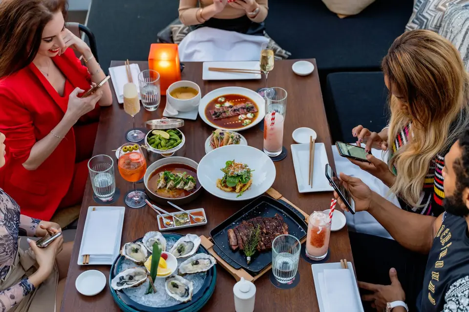 Guests sharing a meal around a lively table.